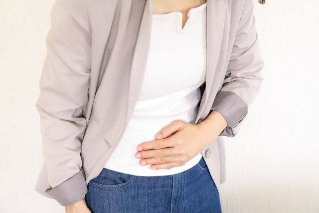 お腹を抑える女性